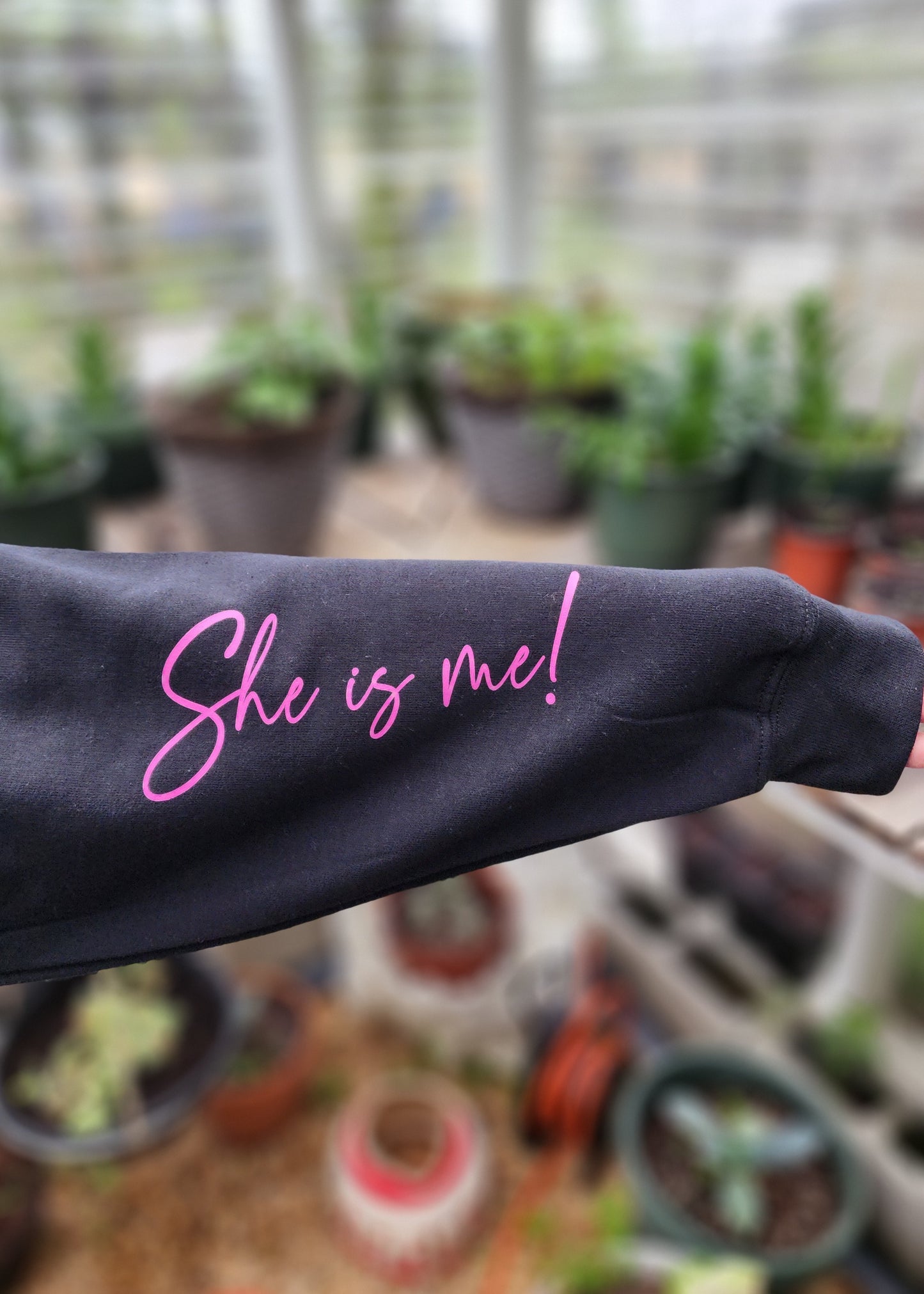 Christian hood with pink writing that says She is me on the sleeve